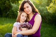 Mother and daughter sitting in a park