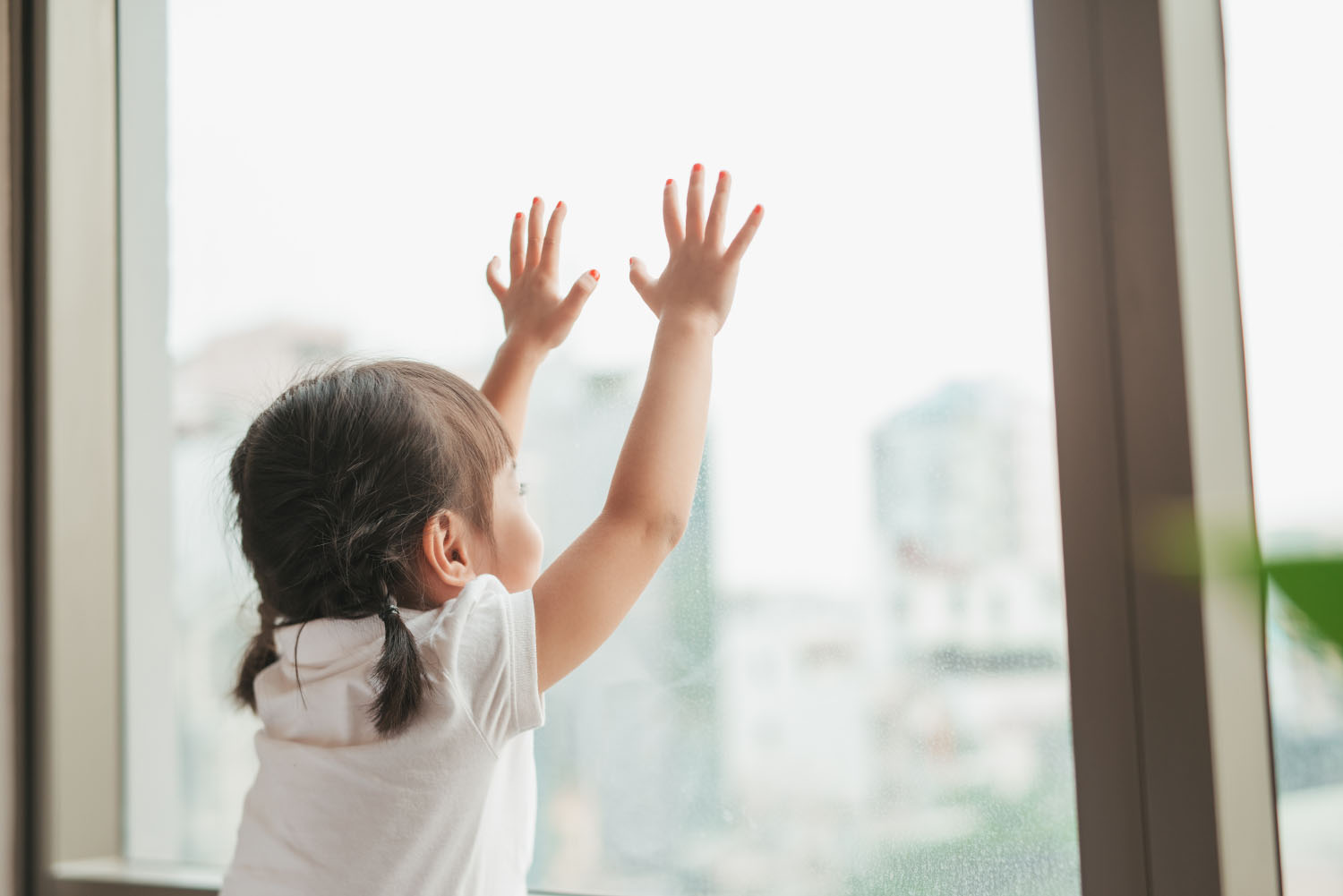 Jeune fille qui regarde par la fenêtre
