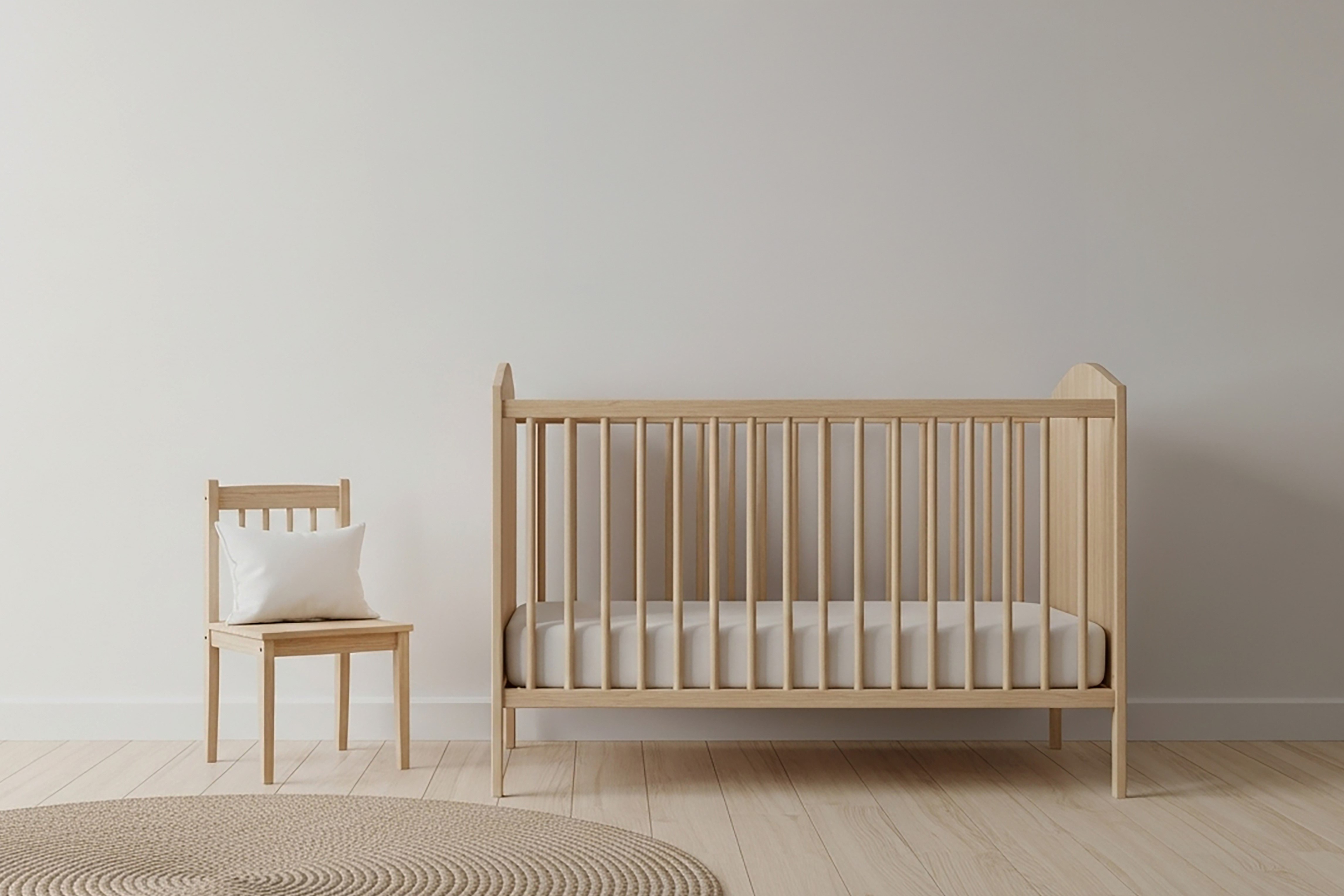 An empty crib with a firm, snug-fitting mattress.